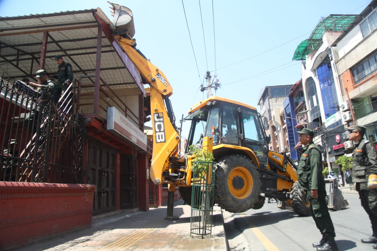 काठमाडाैं महानगरले चलायाे त्रिदेवी मन्दिर ठमेलमा बनेको अनाधिकृत संरचनामा डाेजर (तस्विरहरू)